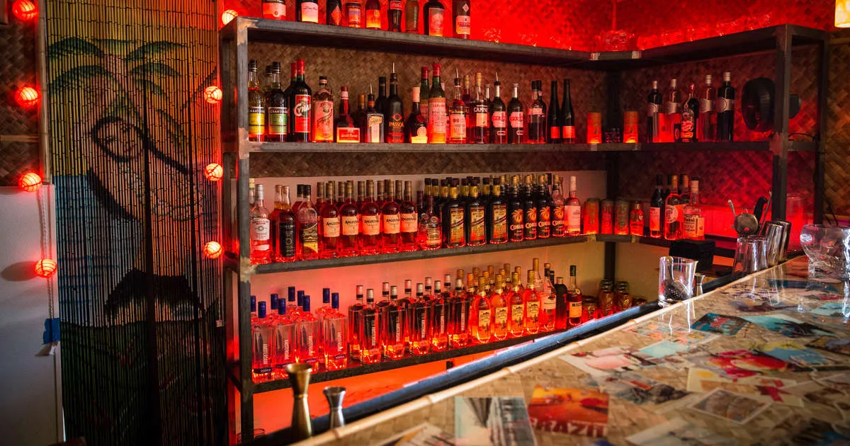 Bootlegger Tiki bar interior in Palm Springs with red-lit rum shelves and tropical tiki decor