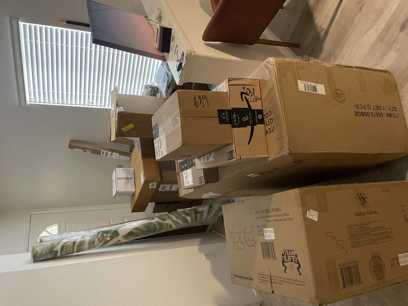 Stacks of delivery boxes filling a room during Cozy Cactus vacation rental setup