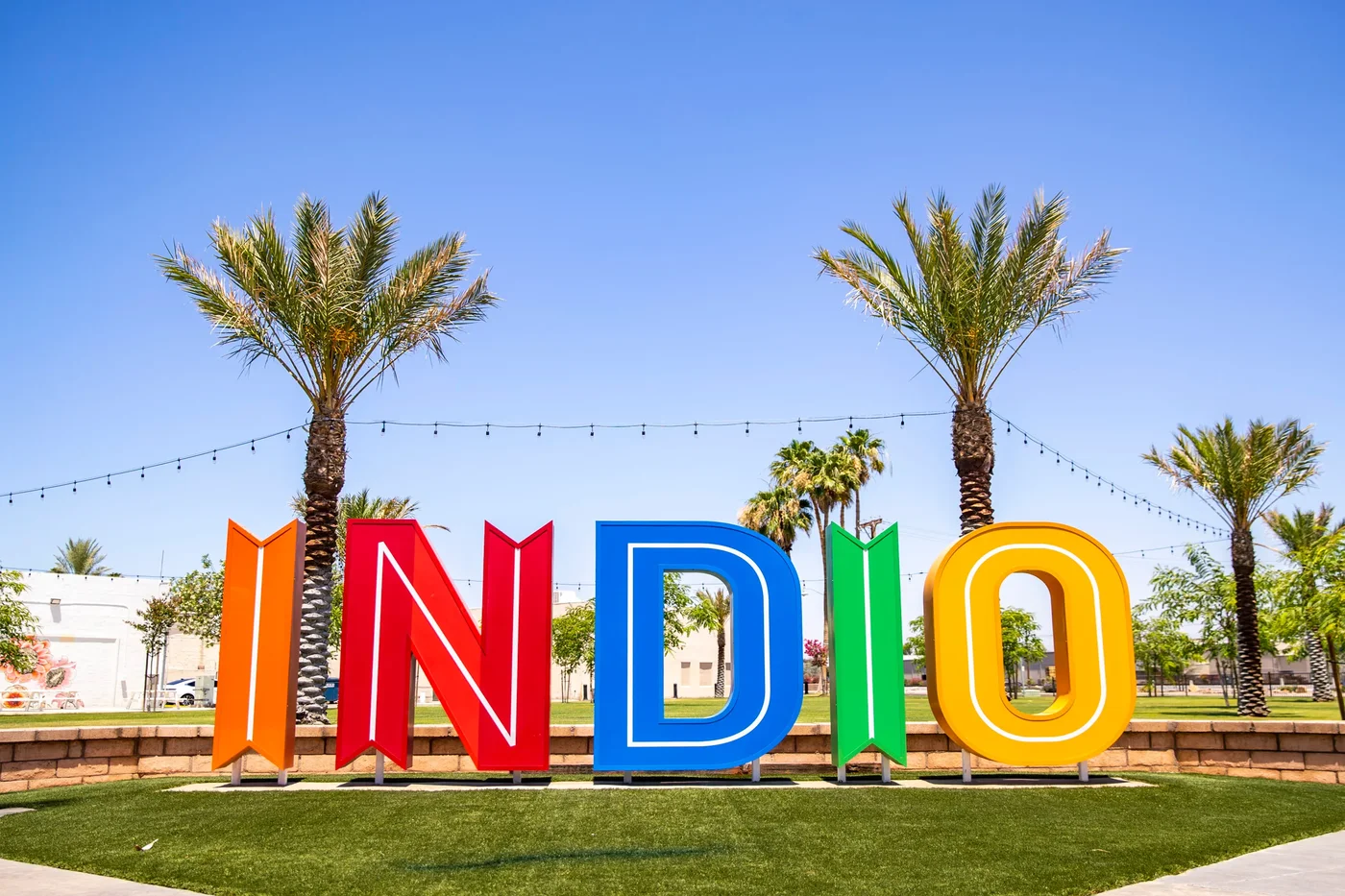 Colorful INDIO letter sign at Miles Avenue Park in Indio California with palm trees