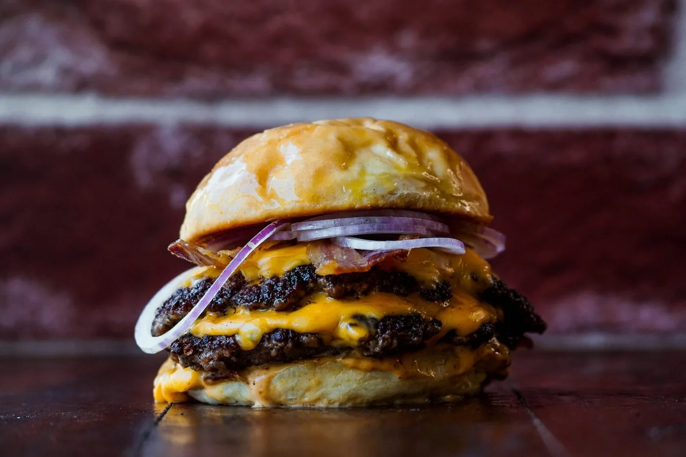 Two Papa Headz smash burgers stacked in paper wrappers, dripping with cheese, Indio CA
