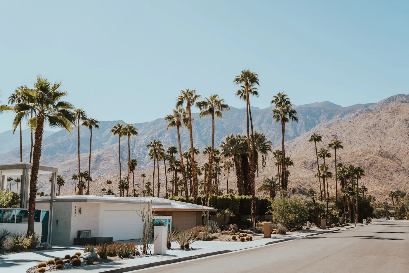 Mid-century modern home with palm trees in the Coachella Valley desert on a clear sunny day