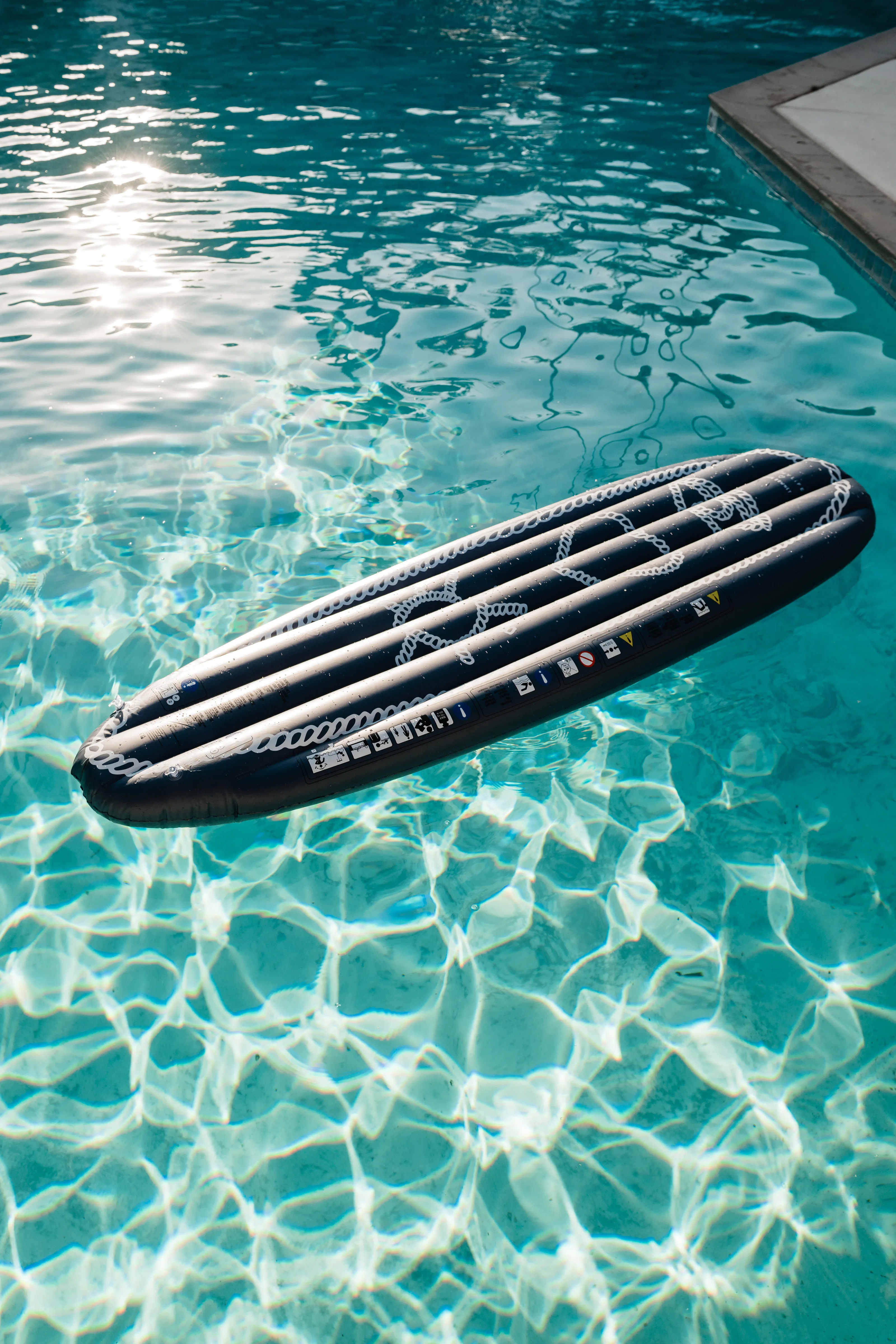 Inflatable surfboard float in The Sundune's shared pool in Palm Springs under bright desert sun
