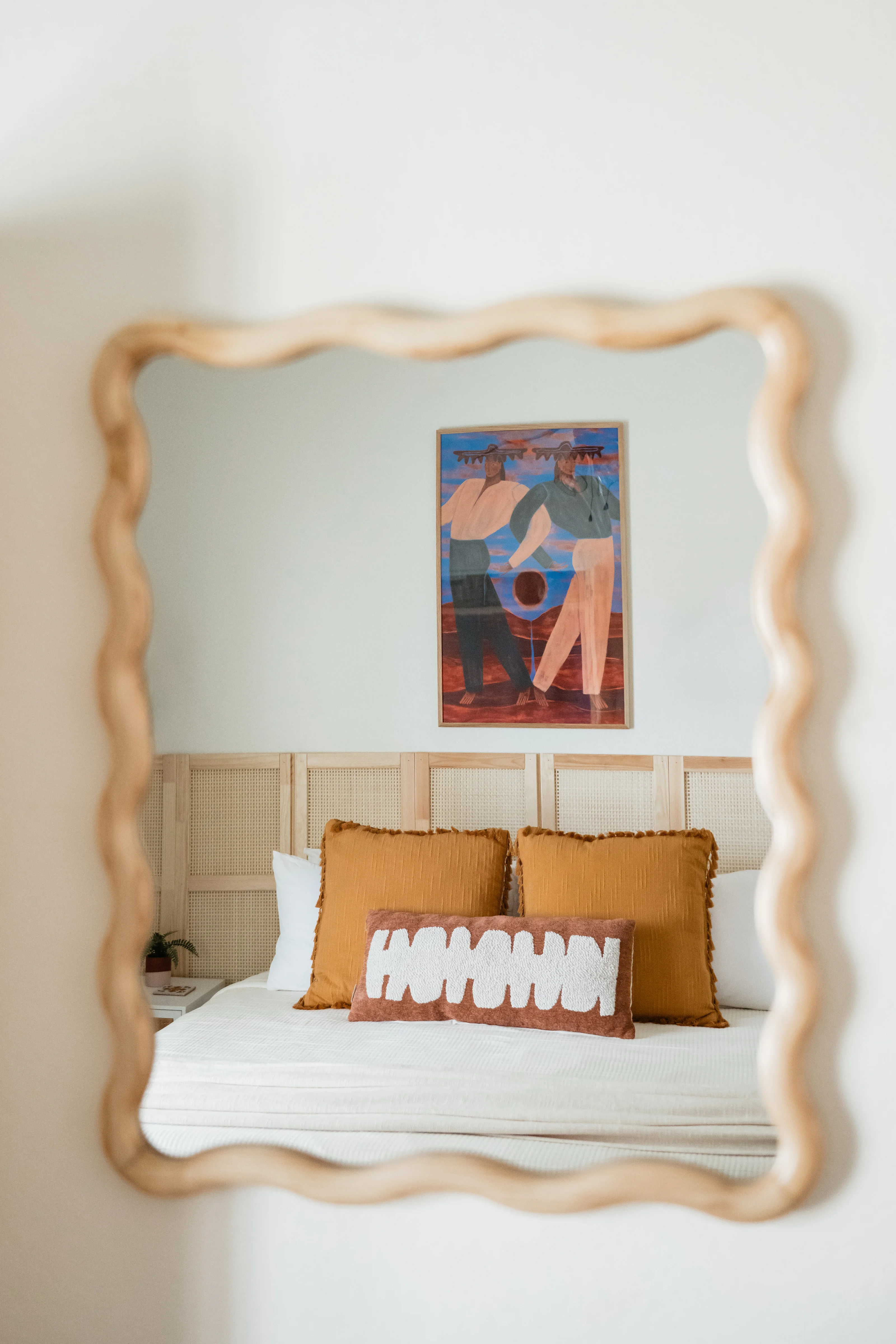 King bed with rattan panel headboard and trundle pulled out in the Cali Room at Terra Luz vacation rental in Indio California
