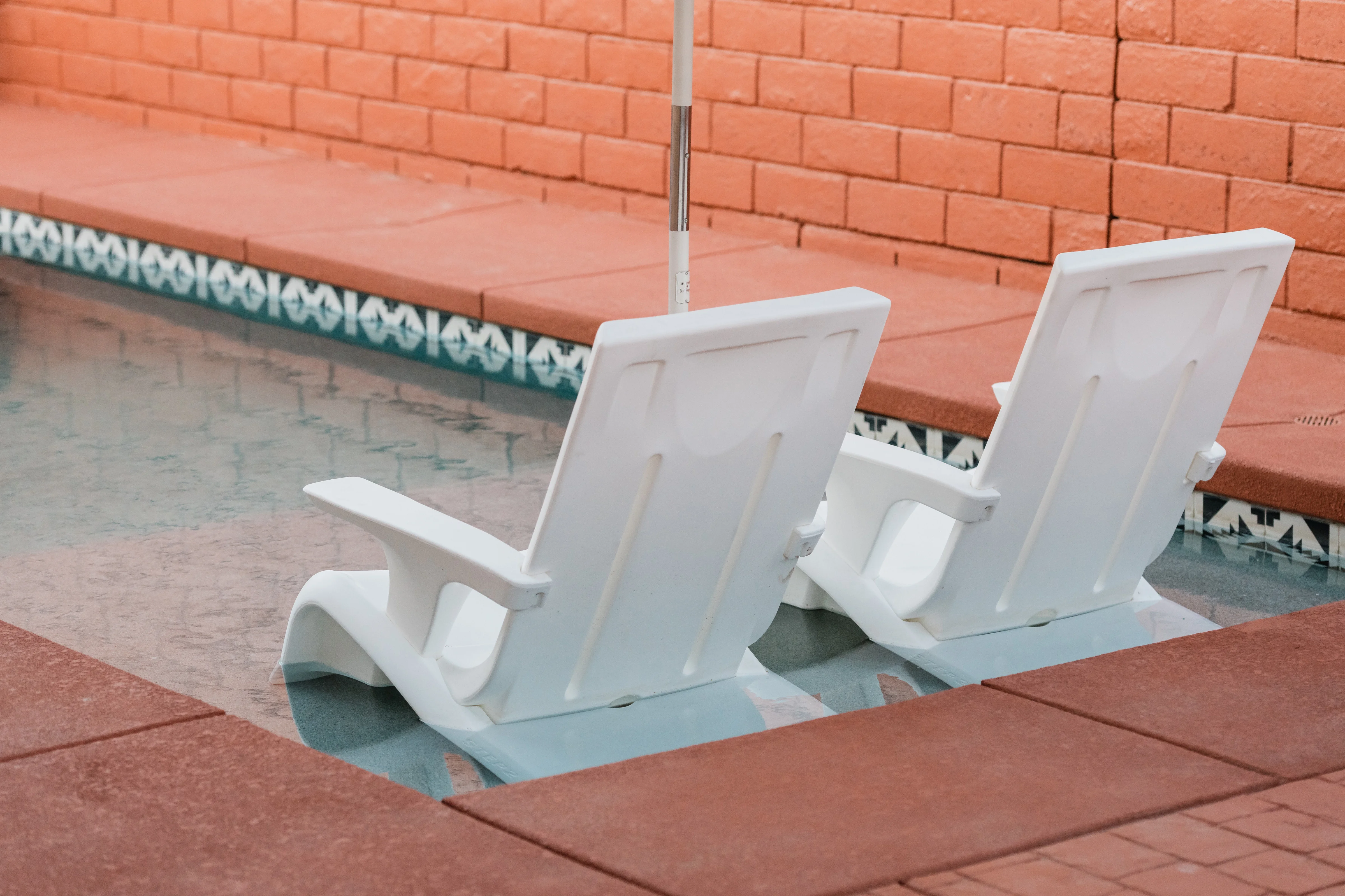 Outdoor lounge chairs beside the pool at Terra Luz vacation rental in Indio, California
