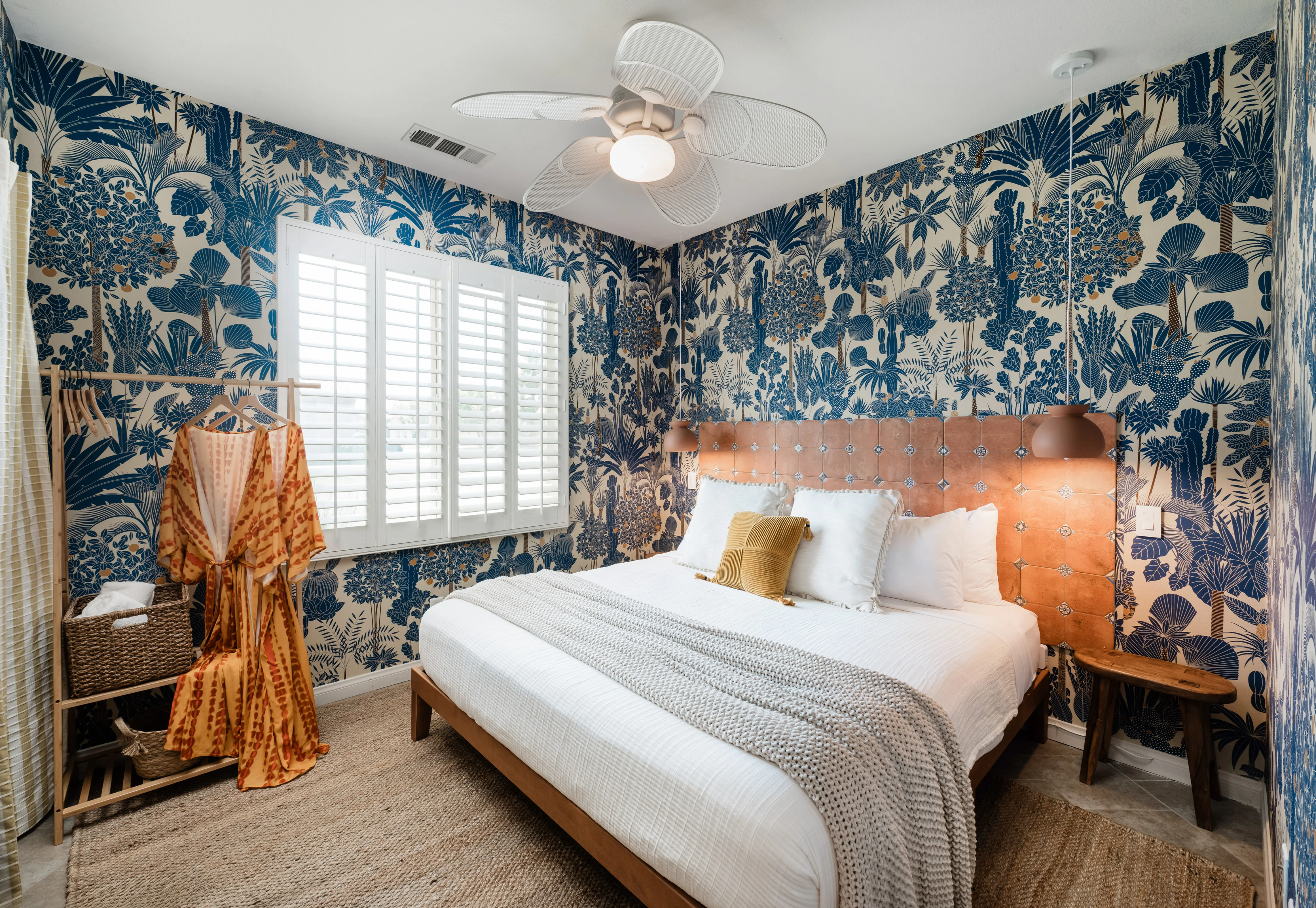 Wild Tropics bedroom at Terra Luz vacation rental with blue botanical wallpaper and terracotta tile headboard