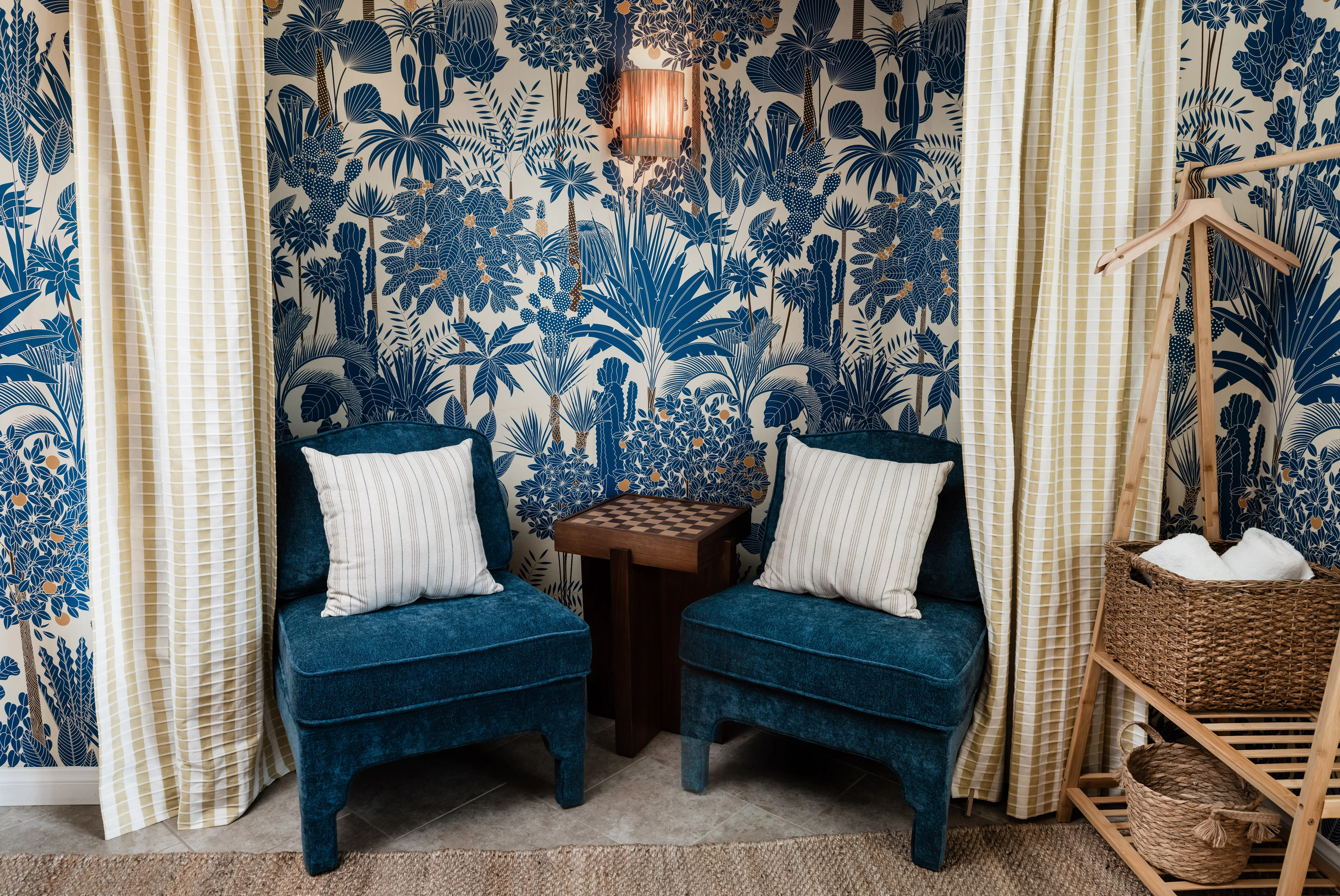 Navy blue velvet chairs and dark wood checkerboard side table in the Wild Tropics seating nook at Terra Luz vacation rental