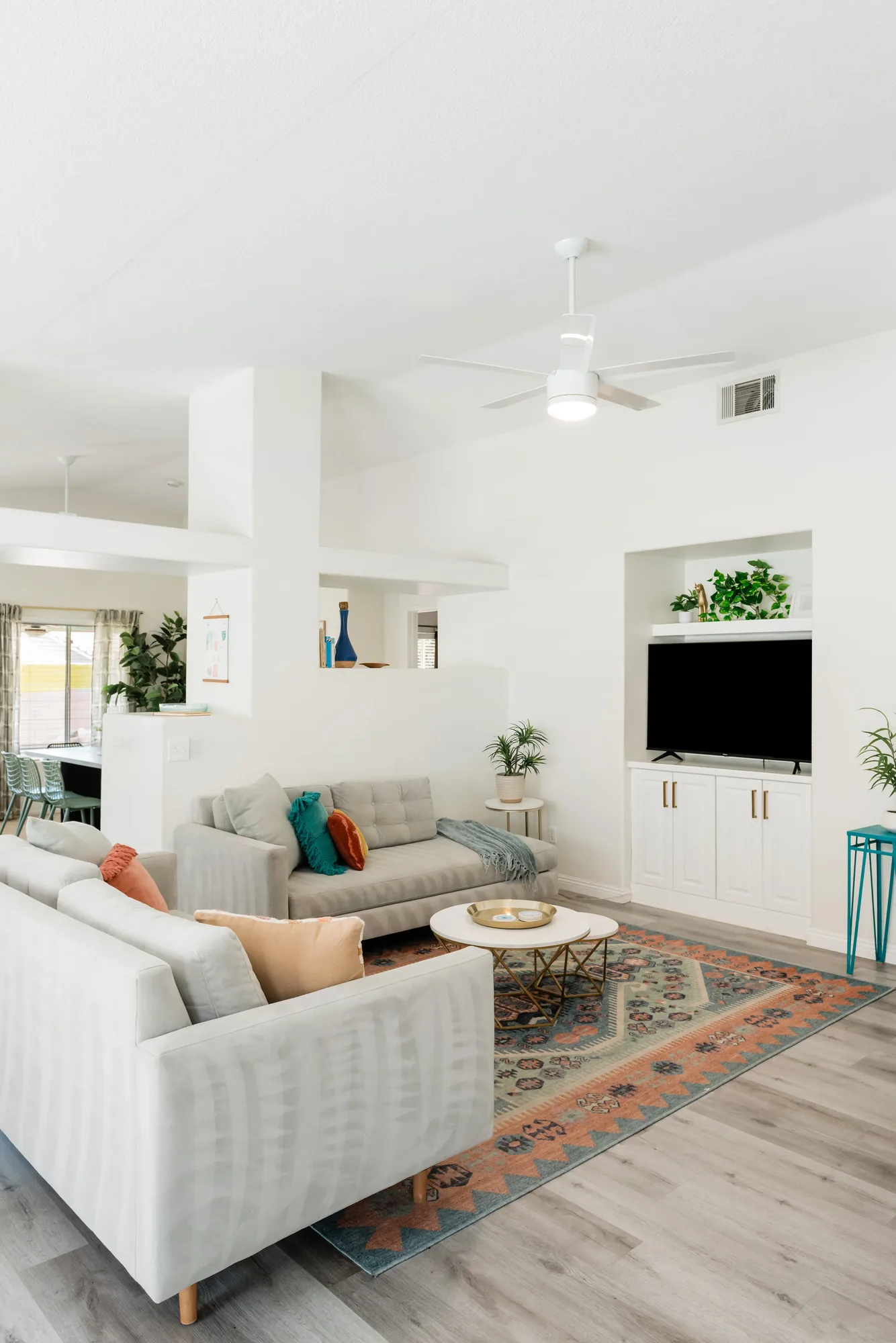 Cozy Cactus open-concept living room with gray linen sofas, kilim rug, and built-in TV