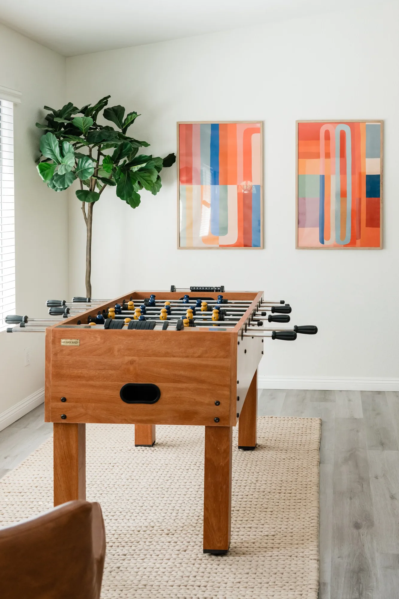 Cozy Cactus foosball table with abstract diptych art and fiddle leaf tree