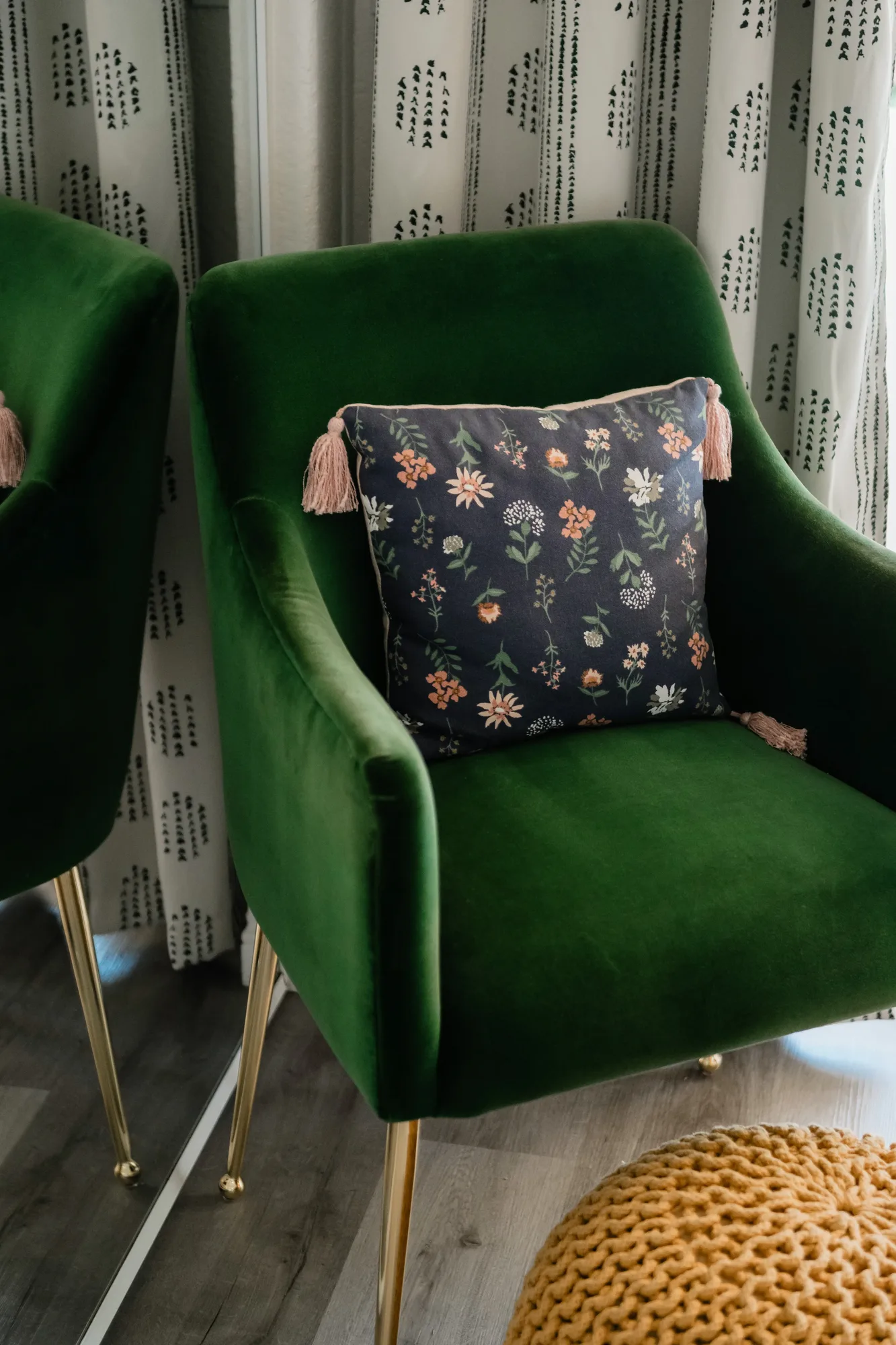 Green velvet chair with floral navy pillow and pink tassel detail in Cozy Cactus primary bedroom
