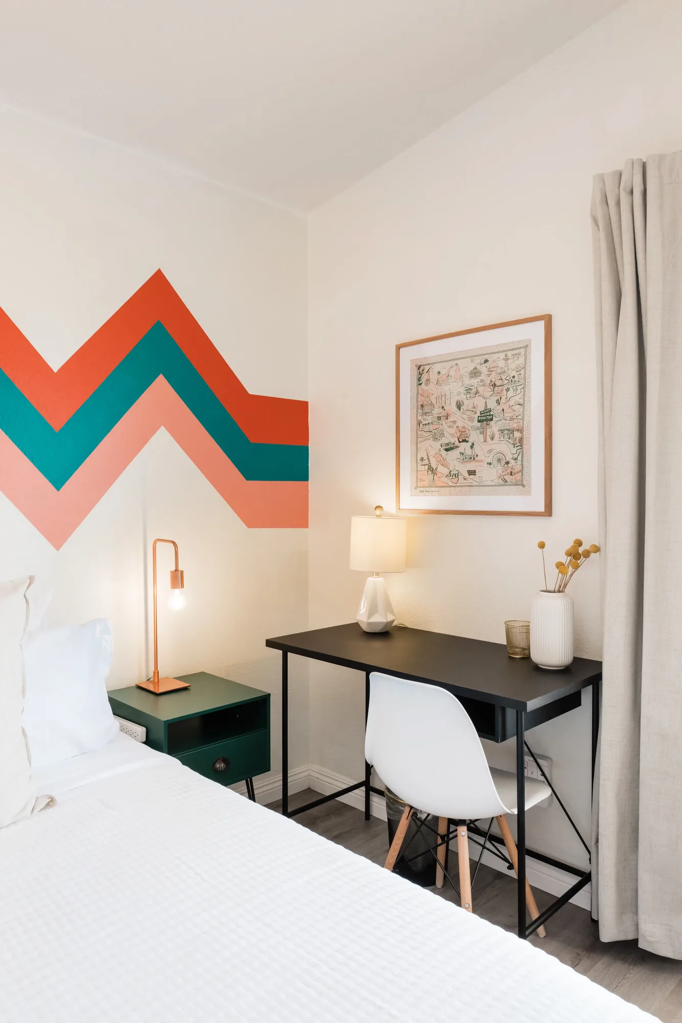 Cozy Cactus bunk bedroom with coral and teal chevron wall, queen bed, and desk