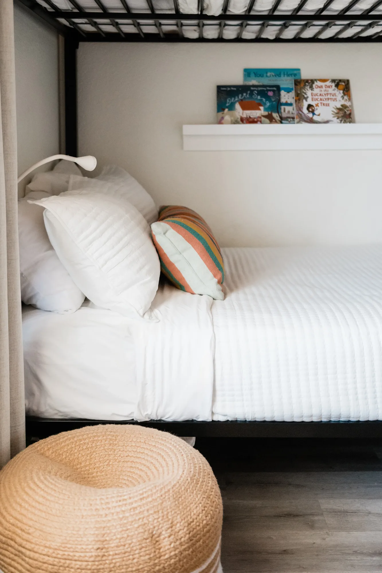 Cozy Cactus bunk bed lower bunk close-up with striped pillow and children books on ledge