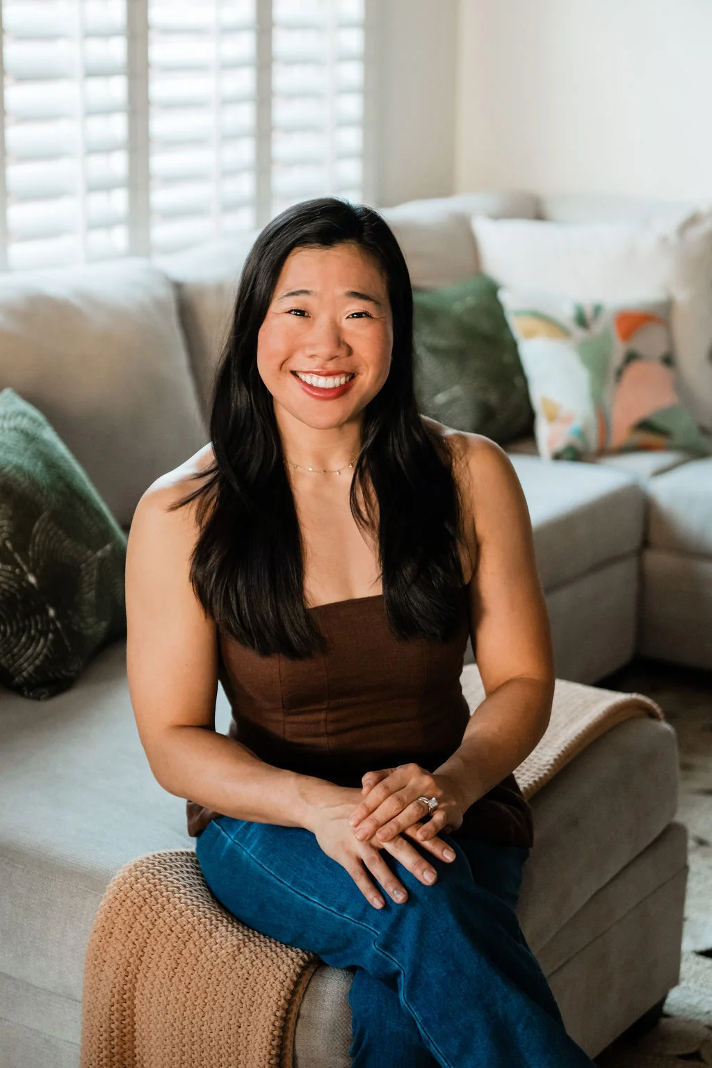 Eann Tuan, host and founder of Indigo Palm Collective, sitting in one of her vacation rentals