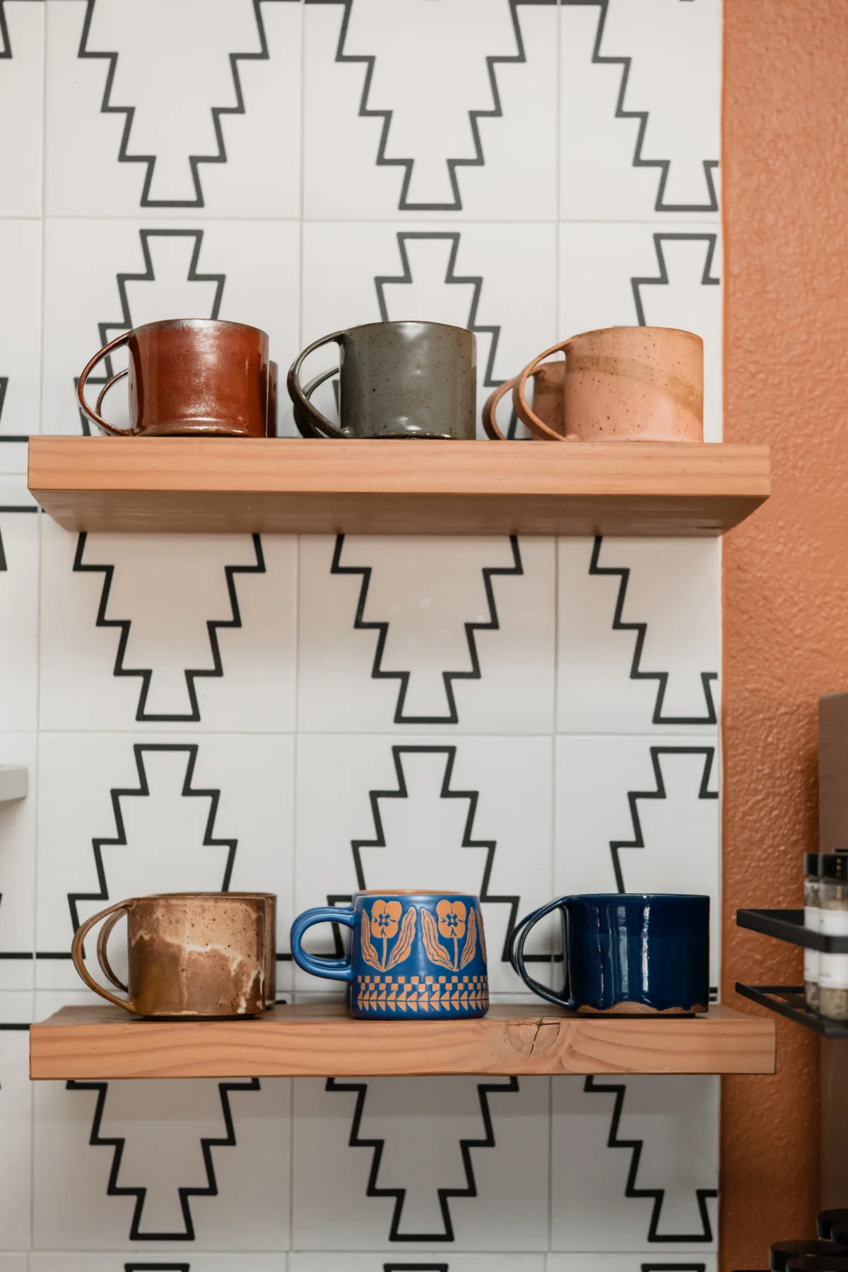 Terra Luz kitchen floating shelves with Leigh Dierck handmade mugs against geometric tile backsplash