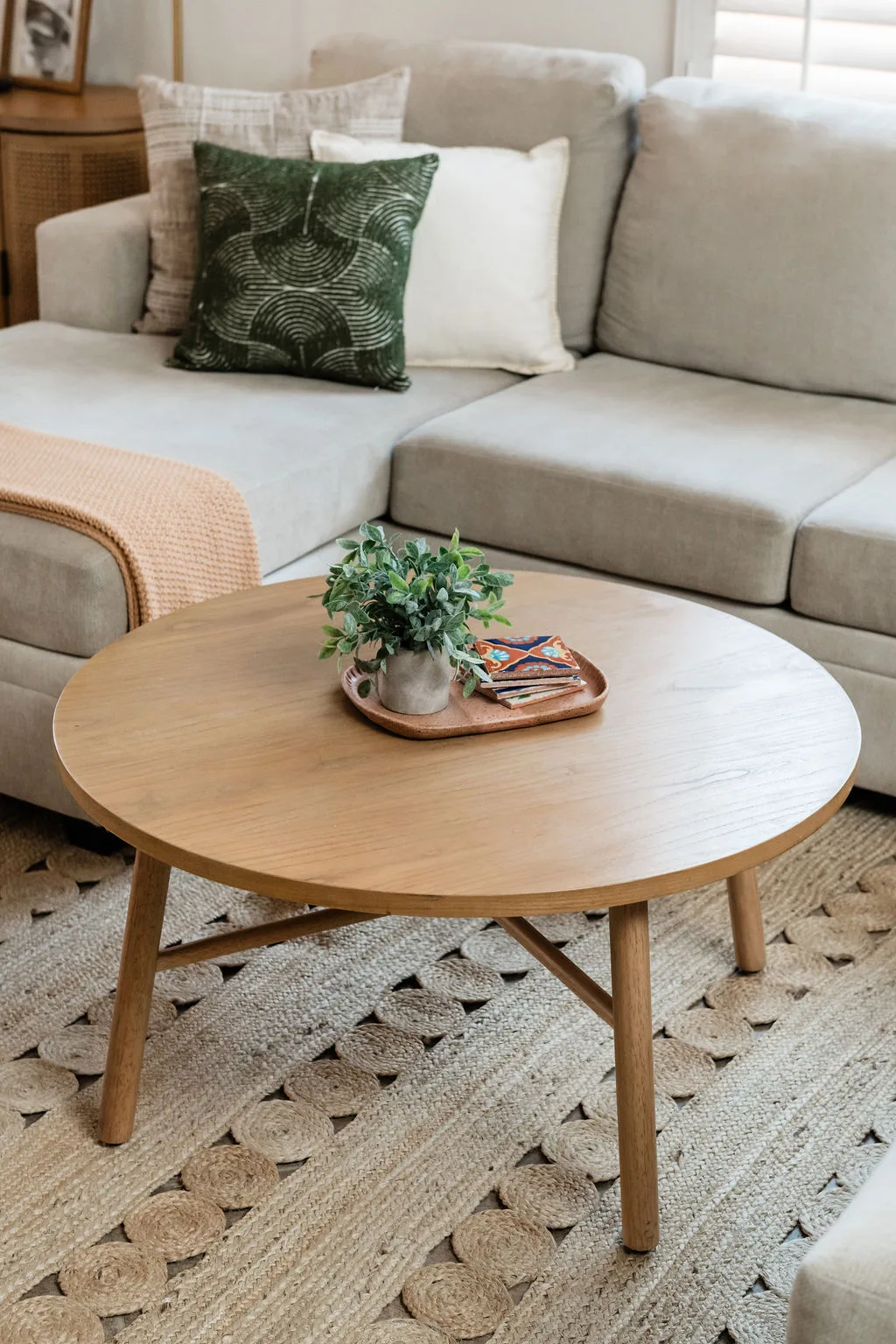 Terra Luz living room wide view with rattan seating, jute rug, and terracotta accent walls