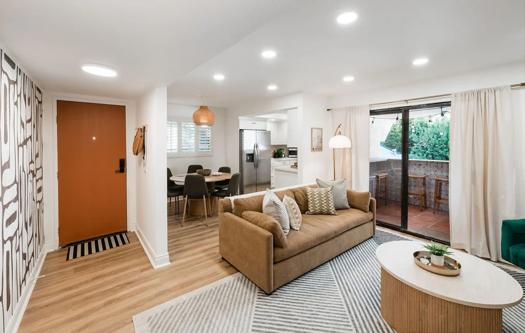 The Sundune Palm Springs living room with camel sofa, orange front door, and balcony