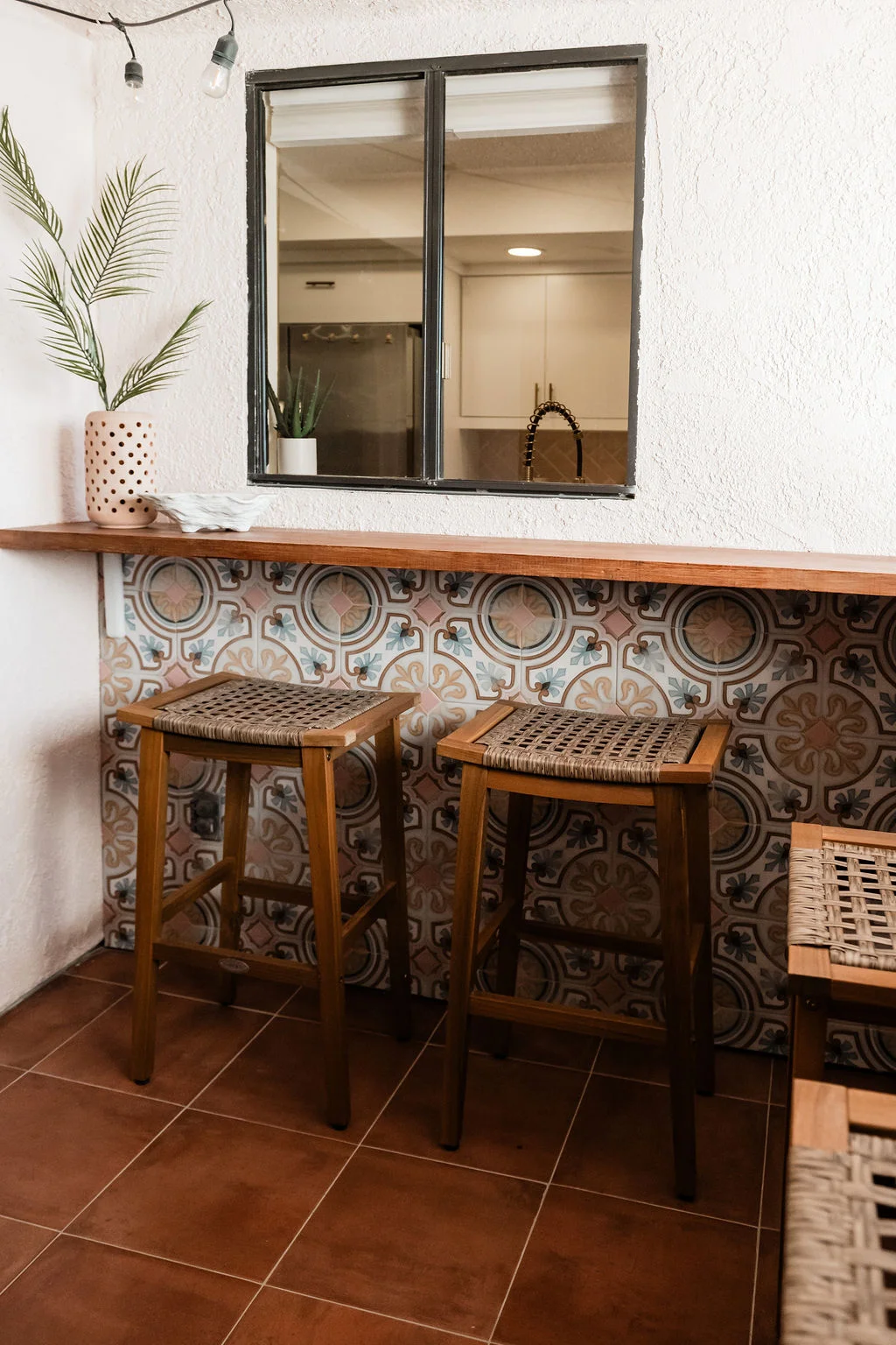 The Sundune Palm Springs private balcony with L-shape bar top, printed cement tile, bar stools, and kitchen pass-through