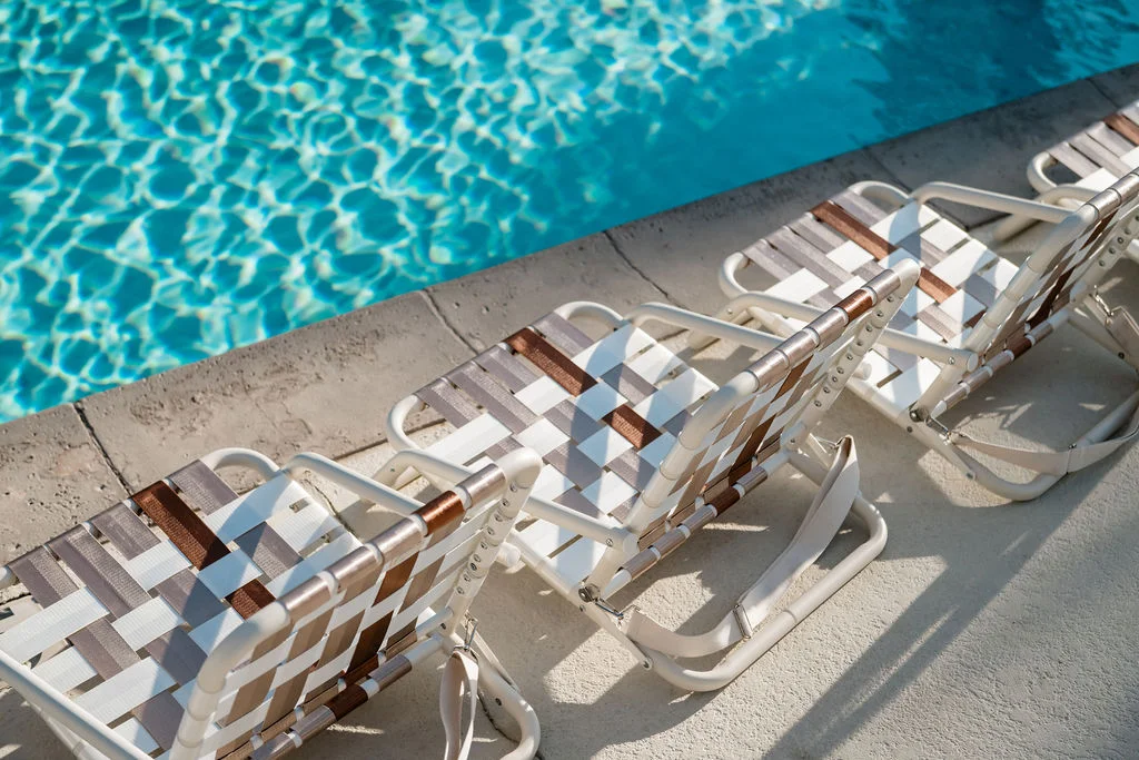 The Sundune Palm Springs community pool with woven lounge chairs and clear blue water