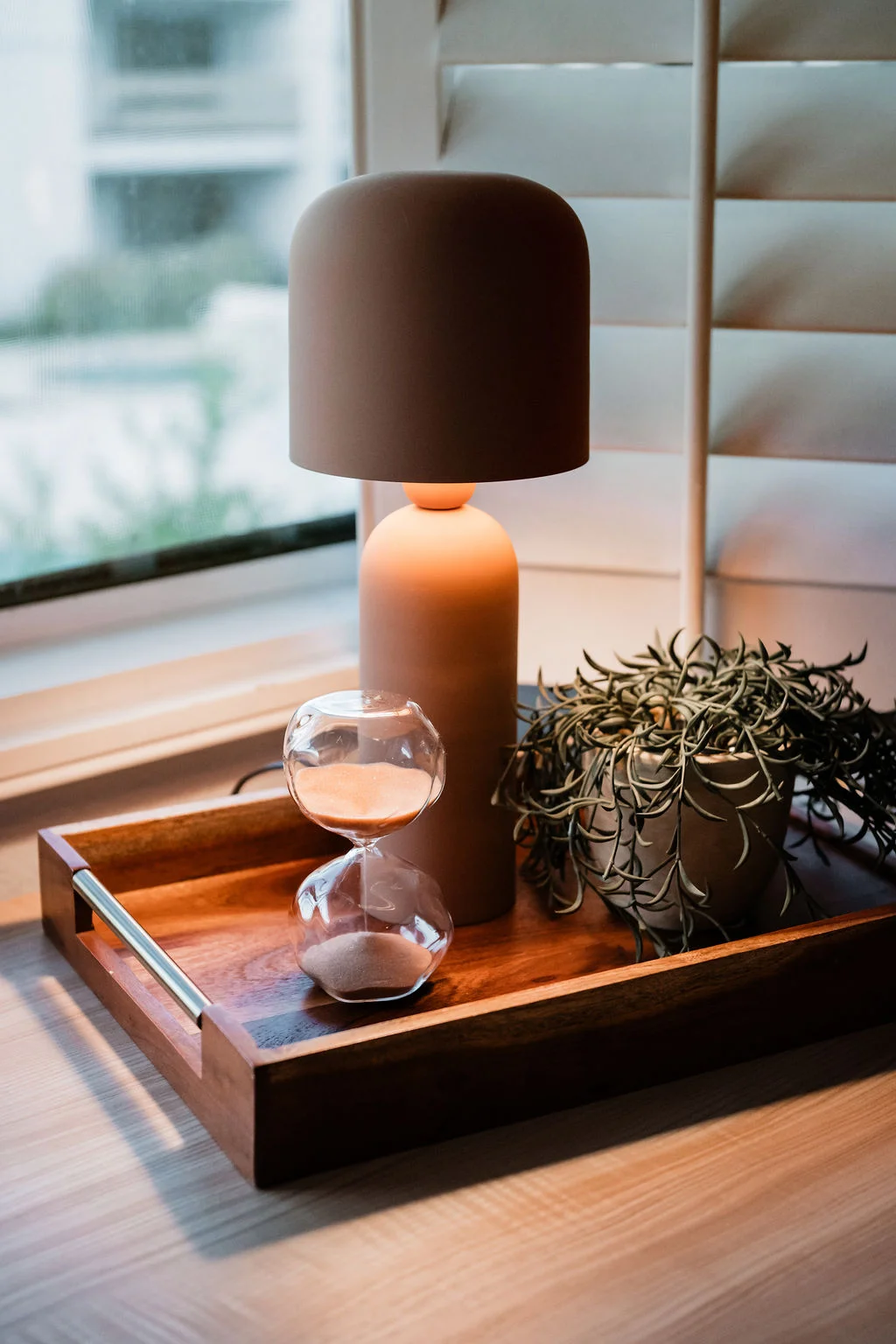 The Sundune Palm Springs bedroom terracotta mushroom lamp and hourglass on wood tray by window